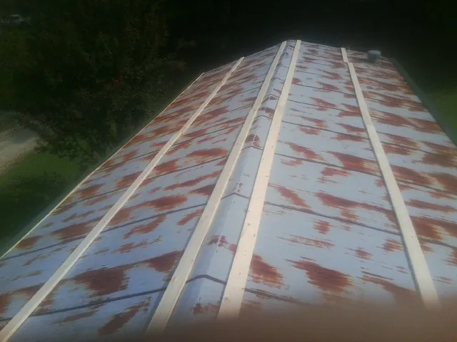 Rusted metal roof panels with new wood purlins before replacement — Storm Damage Roof Repair in Spencertown by Roofing Brothers